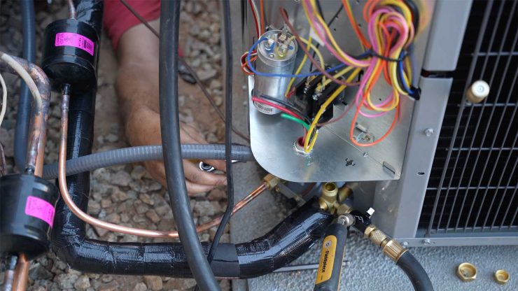 Image of heating repair and installation job with technician fixing wiring.