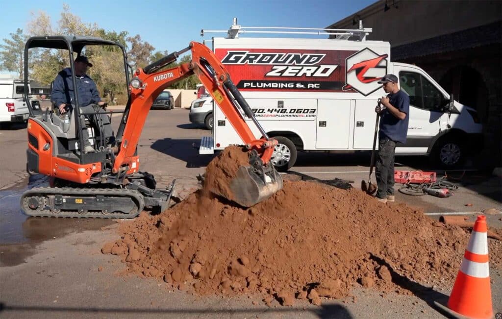 Using the back-ho to locate a broken pipe for repair